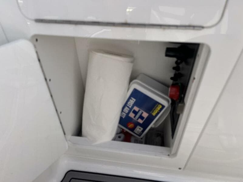 Storage compartment in a 2022 Monterey M-45 boat with paper towels and first aid kit.