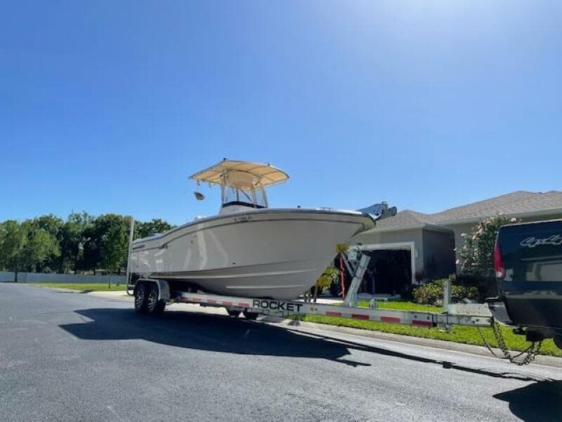 2014 Grady-White Fisherman 257 boat on a trailer in a residential area.