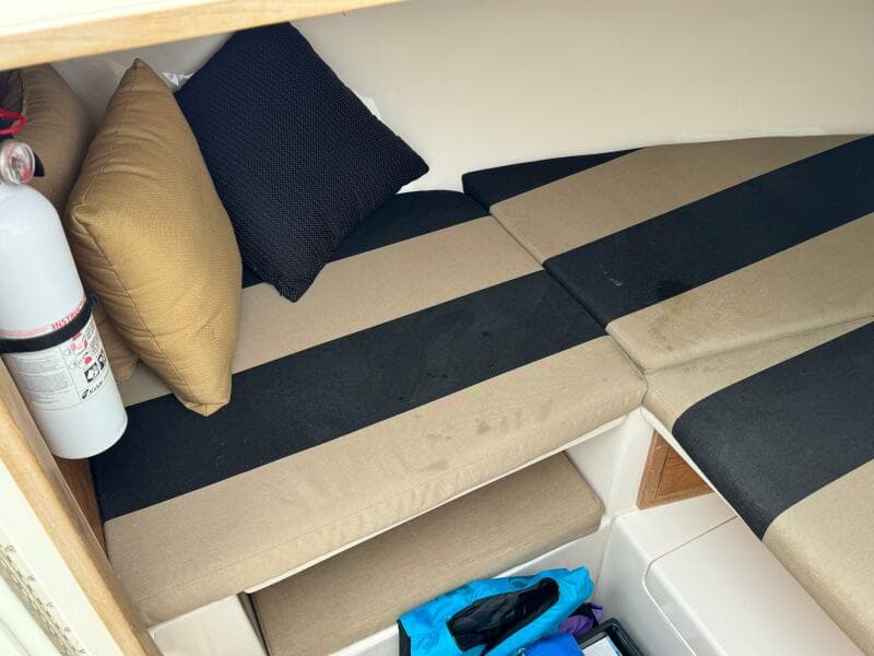 2004 Intrepid 32 Cuddy cabin interior with striped cushions and pillows.
