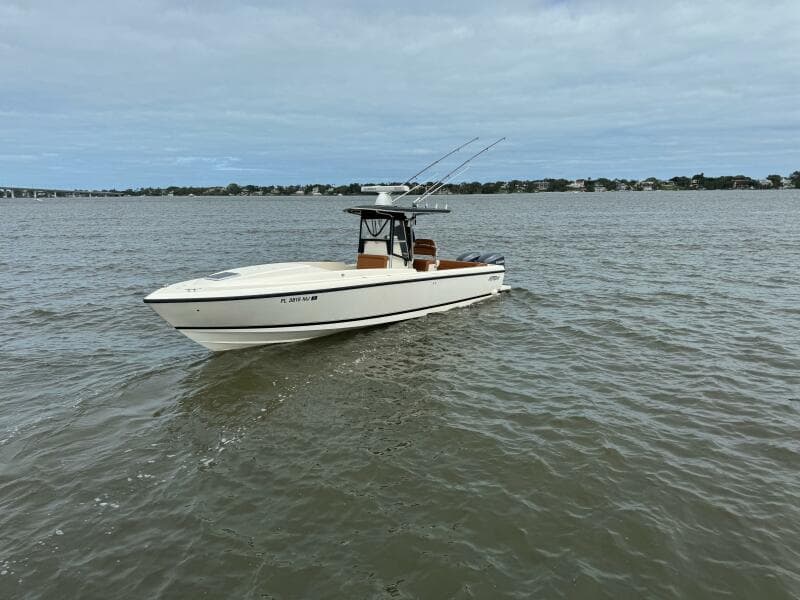 2004 Intrepid 32 Cuddy boat on open water under cloudy sky.