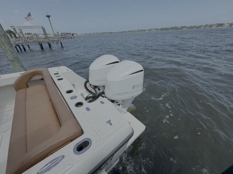 2004 Intrepid 32 Cuddy boat with dual outboard motors on the water.