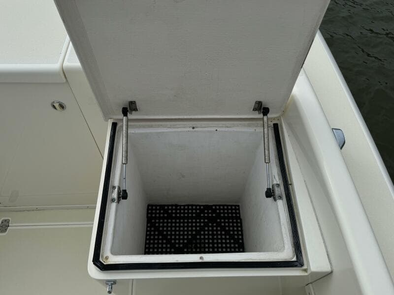 Open storage compartment on a 2004 Intrepid 32 Cuddy boat.