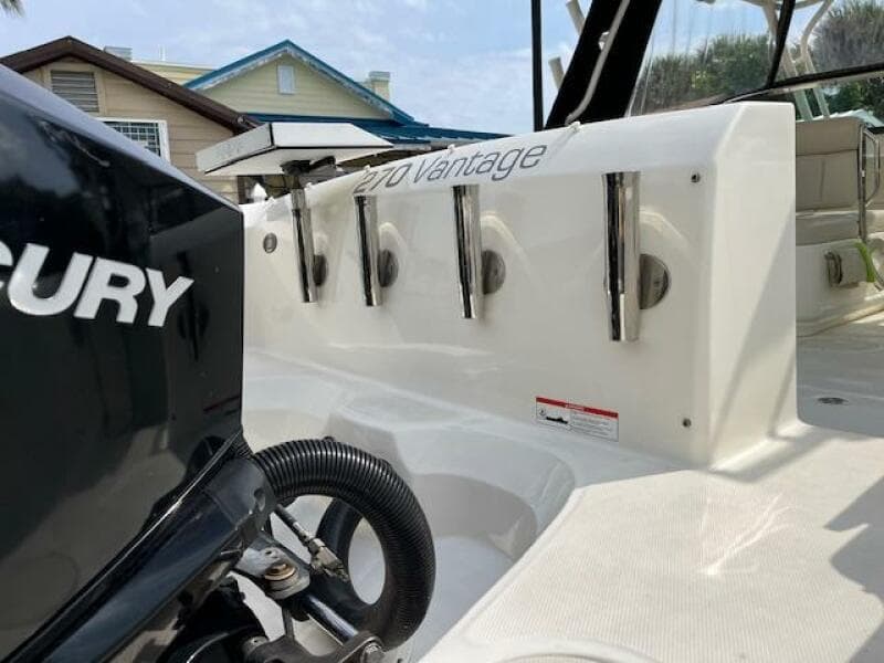 2018 Boston Whaler 270 Vantage boat with Mercury engine, docked near houses.