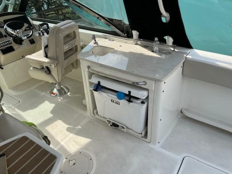 2018 Boston Whaler 270 Vantage boat interior with helm, sink, and cooler.