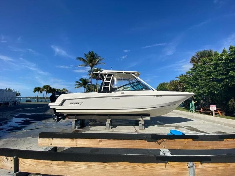 2018 Boston Whaler 270 Vantage boat on a dock with palm trees in the background.