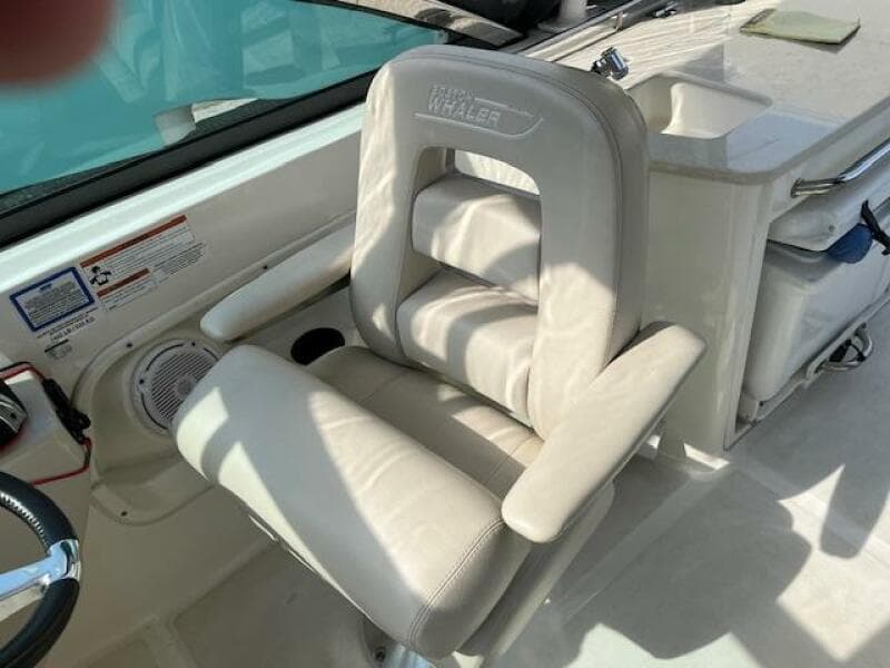 2018 Boston Whaler 270 Vantage captain's chair with armrests and white upholstery.