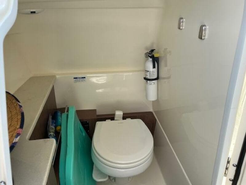 2018 Boston Whaler 270 Vantage boat interior bathroom with toilet and fire extinguisher.