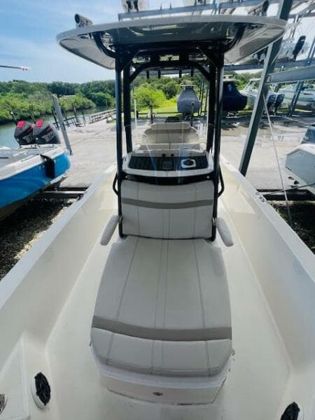2023 Boston Whaler 250 Dauntless boat interior with seating and console, docked outdoors.