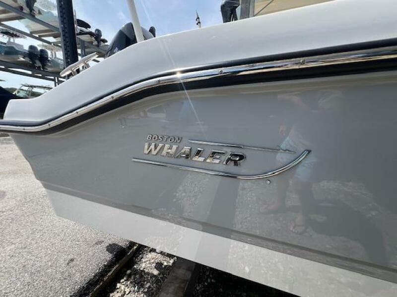 2023 Boston Whaler 250 Dauntless boat side view with logo and chrome detailing.