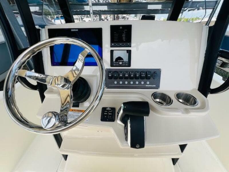 2023 Boston Whaler 250 Dauntless helm with steering wheel, controls, and display screen.