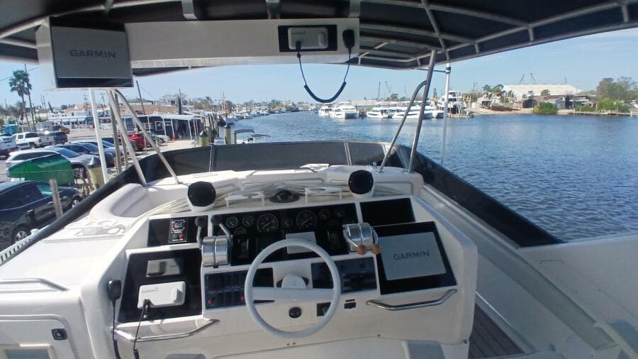 1997 Sea Ray 550 Sedan Bridge helm with Garmin navigation, overlooking marina and waterfront.