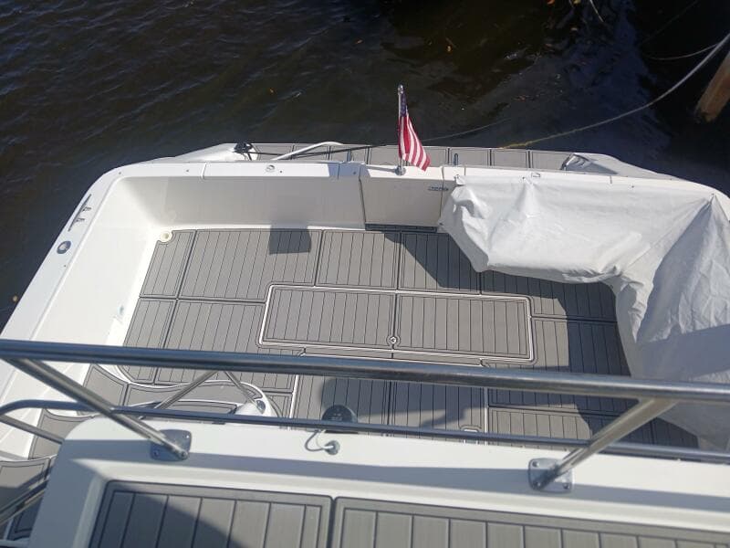 1997 Sea Ray 550 Sedan Bridge deck with American flag, docked on calm water.