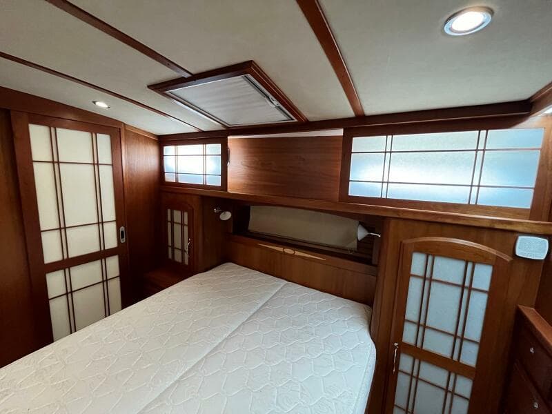 2013 Sabre 48 Salon Express bedroom with wood paneling and frosted glass accents.