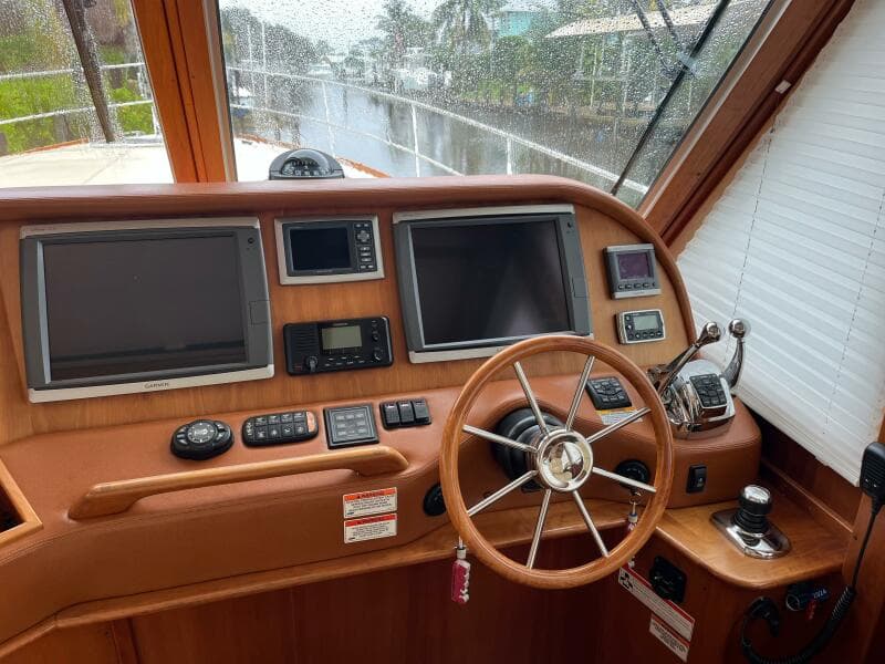 2013 Sabre 48 Salon Express helm with dual screens and wooden steering wheel.