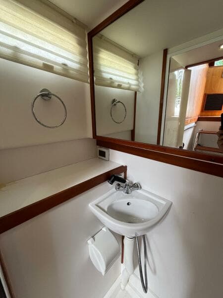 Compact bathroom in 2013 Sabre 48 Salon Express yacht with sink and mirror.