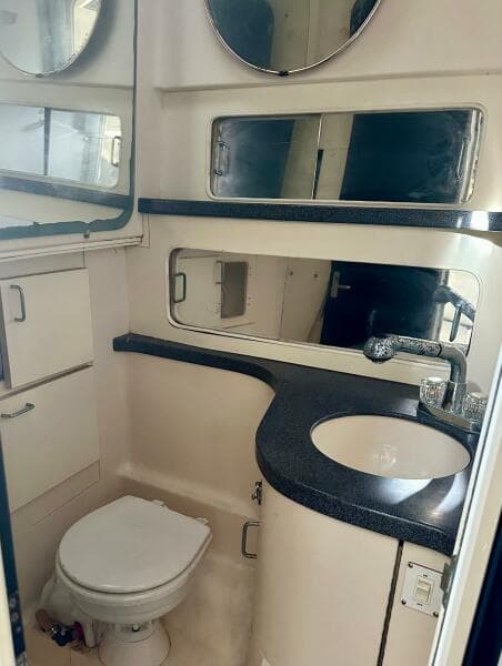 2000 Luhrs Tournament 320 Open bathroom with sink, toilet, and storage cabinets.