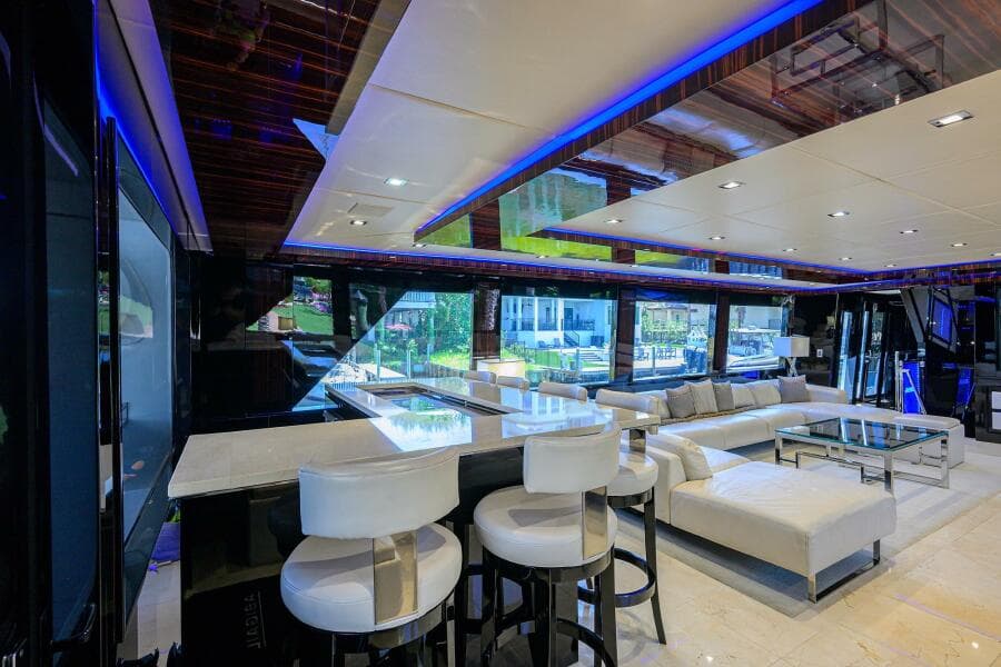 Luxurious interior of 1997 Broward 108 Raised Pilothouse yacht with modern seating and ambient lighting.