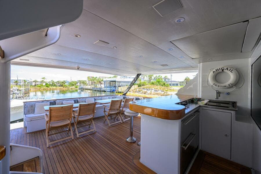 Spacious deck of 1997 Broward 108 Raised Pilothouse yacht with outdoor seating and bar area.