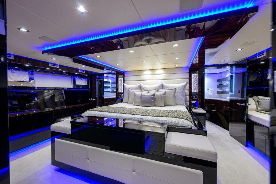 Luxurious bedroom interior of 1997 Broward 108 Raised Pilothouse yacht with blue LED lighting.