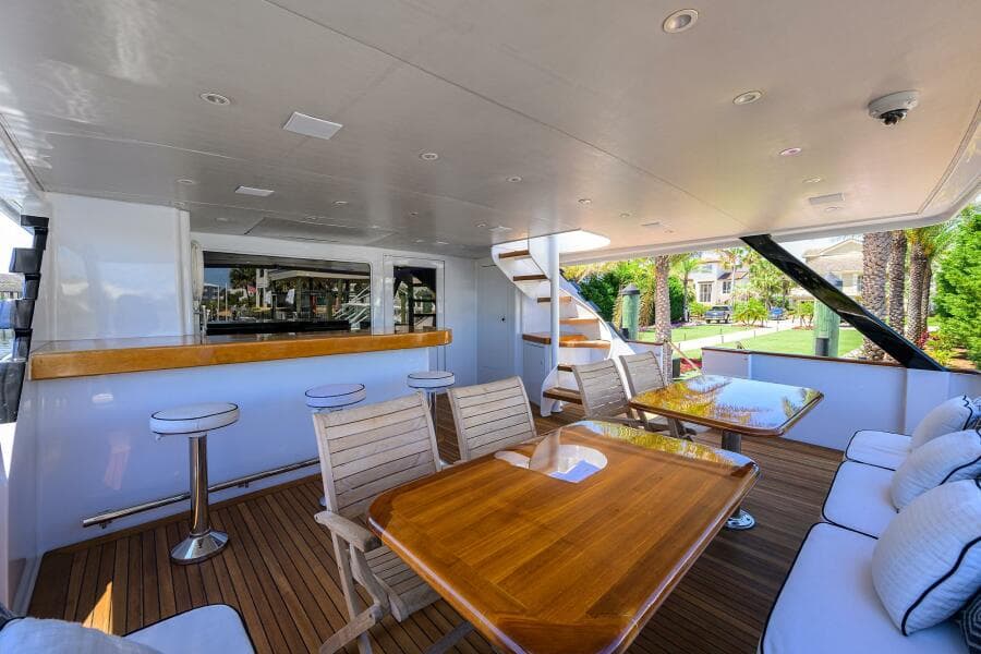 Spacious deck of 1997 Broward 108 Raised Pilothouse yacht with seating and bar area.