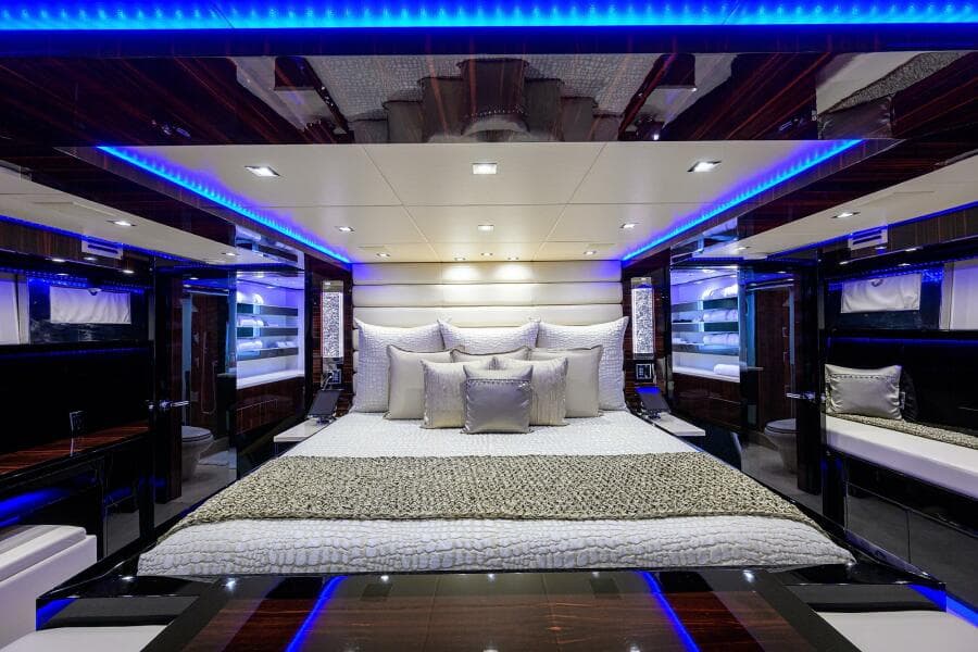 Luxurious bedroom interior of 1997 Broward 108 Raised Pilothouse yacht with blue LED lighting.