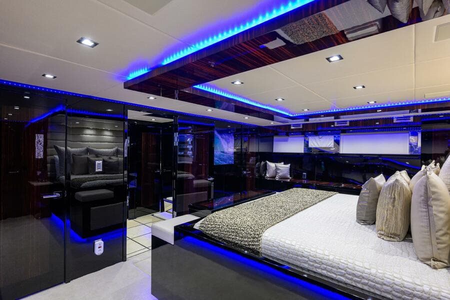 Luxurious bedroom interior of 1997 Broward 108 Raised Pilothouse yacht with modern lighting.