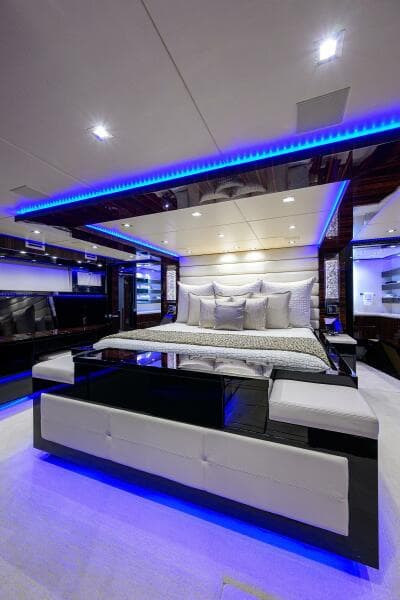 Luxurious bedroom interior of 1997 Broward 108 Raised Pilothouse yacht with modern lighting.