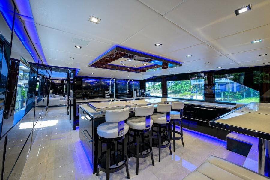 Luxurious interior of 1997 Broward 108 Raised Pilothouse yacht with modern bar and seating.