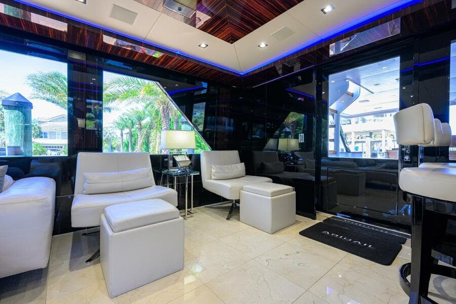 Luxurious interior of 1997 Broward 108 Raised Pilothouse yacht with modern seating and large windows.
