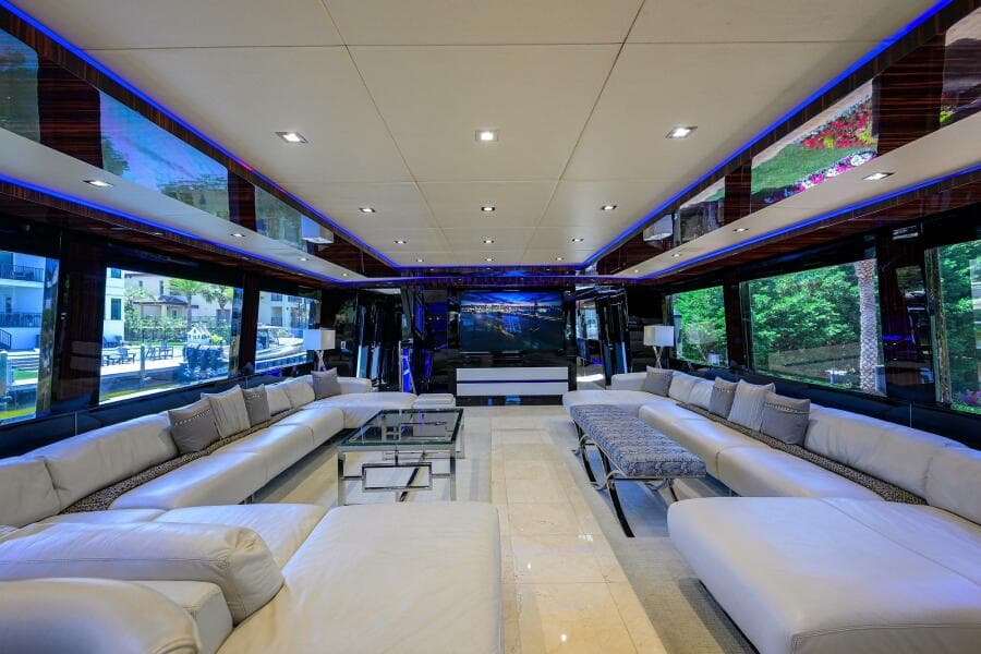 Luxurious interior of 1997 Broward 108 Raised Pilothouse yacht with modern seating and large windows.