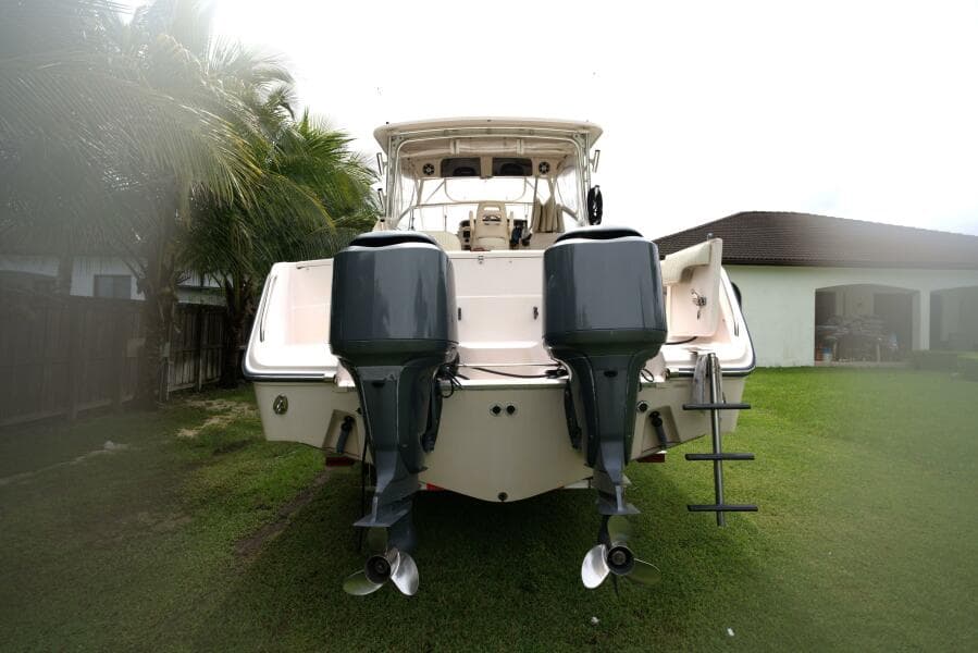 2007 Grady-White Express 330 boat with dual outboard motors on grassy lawn.