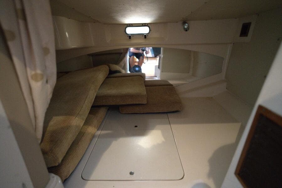 Interior cabin of 2007 Grady-White Express 330 boat with cushions and small window.