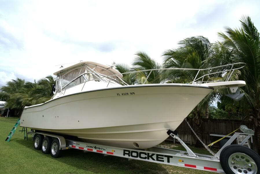 2007 Grady-White Express 330 boat on trailer, surrounded by palm trees.