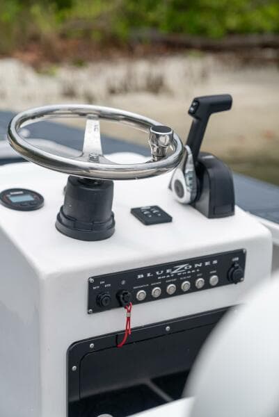 2025 BlueZones Boatworks 16' Flats steering console with controls and steering wheel.