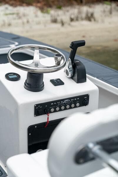 2025 BlueZones Boatworks 16' Flats steering console with controls and steering wheel.