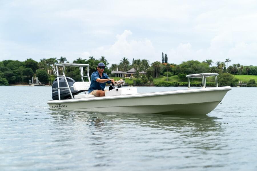 2025 BlueZones Boatworks 16' Flats boat on calm water with driver.
