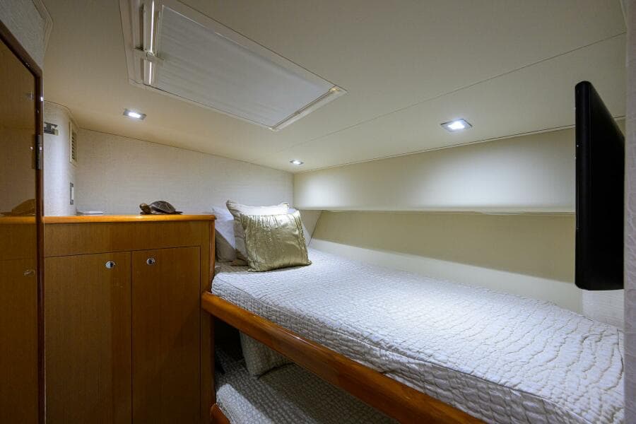 2004 Viking 65 Enclosed Bridge w/Tower cabin interior with single bed and storage.