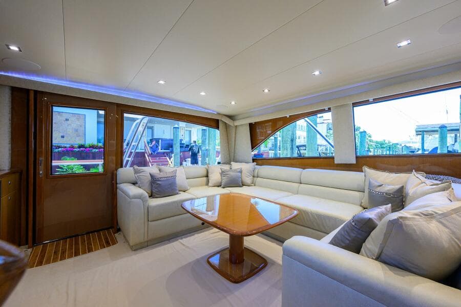 Luxurious interior of 2004 Viking 65 Enclosed Bridge yacht with plush seating and wooden table.