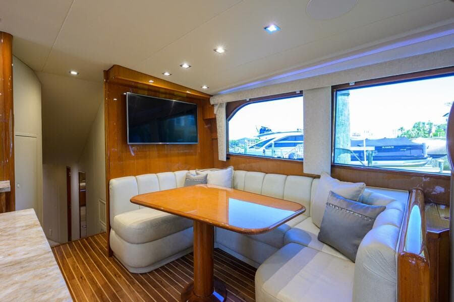 Luxurious interior of 2004 Viking 65 Enclosed Bridge yacht with dining area and TV.