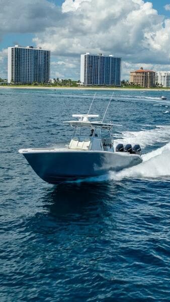 2025 Billfish 39 Center Console boat cruising near coastal skyscrapers.
