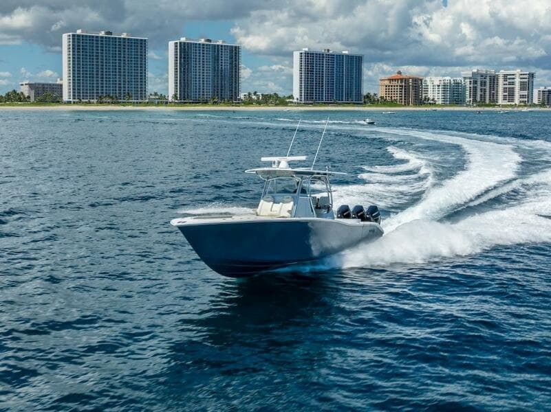 2025 Billfish 39 Center Console boat cruising near coastal skyscrapers.