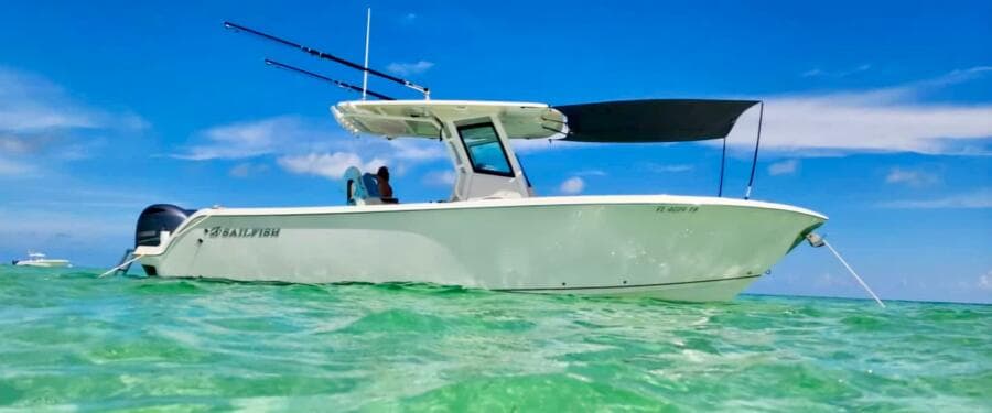 2021 Sailfish 272 CC boat anchored in clear turquoise water under a blue sky.