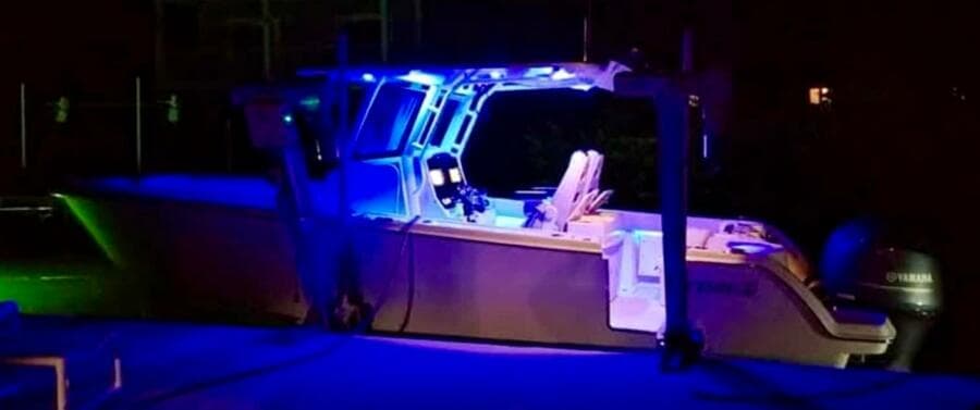 2021 Sailfish 272 CC boat illuminated with blue lights at night.