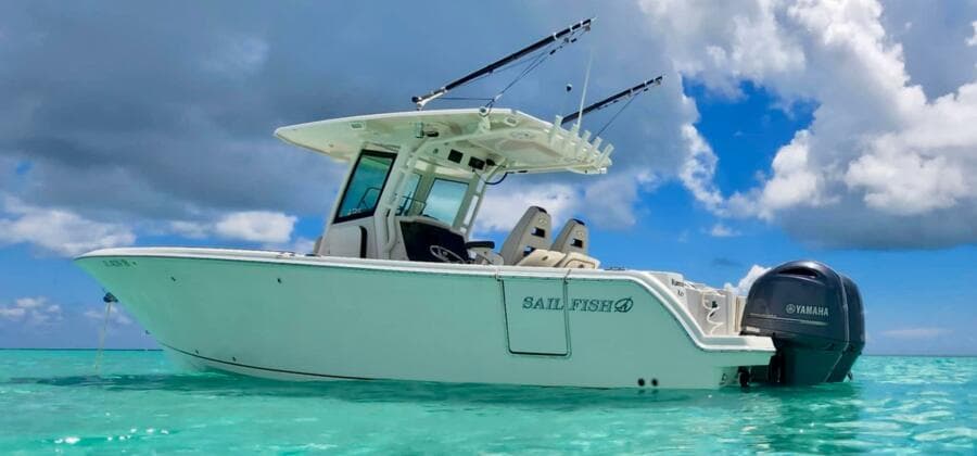 2021 Sailfish 272 CC boat on clear turquoise water under cloudy sky.