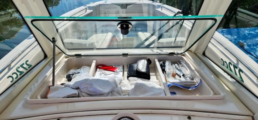 Open storage compartment on 2021 Sailfish 272 CC boat with various items inside.