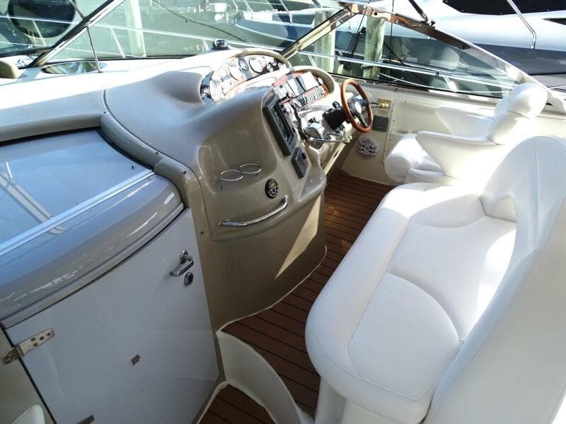Cockpit of 2001 Sea Ray 410 Sundancer with white seating and wooden flooring.