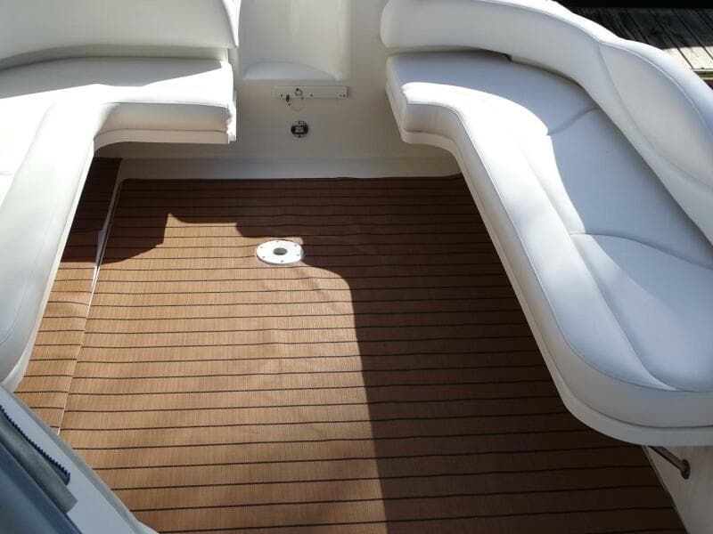 2001 Sea Ray 410 Sundancer cockpit with white seating and teak flooring.