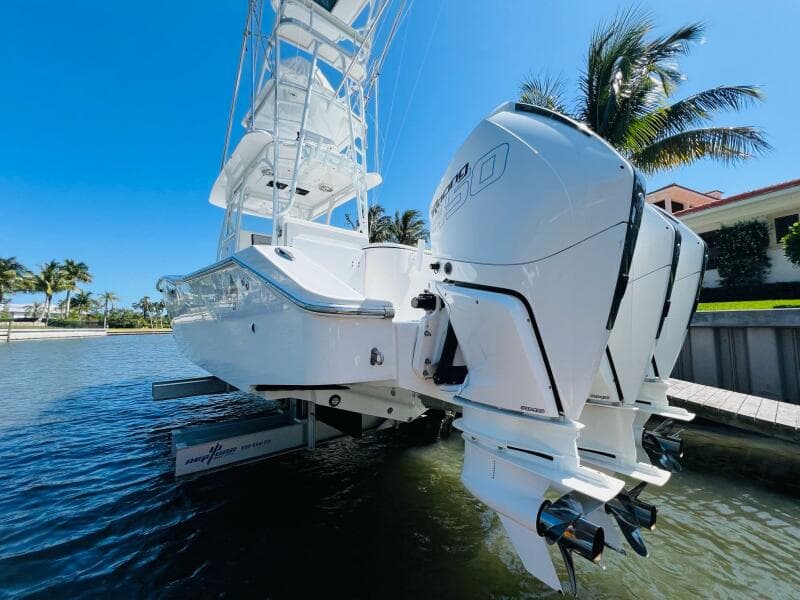 2015 Billfish 39 Custom CC boat with twin outboard engines docked by palm trees.