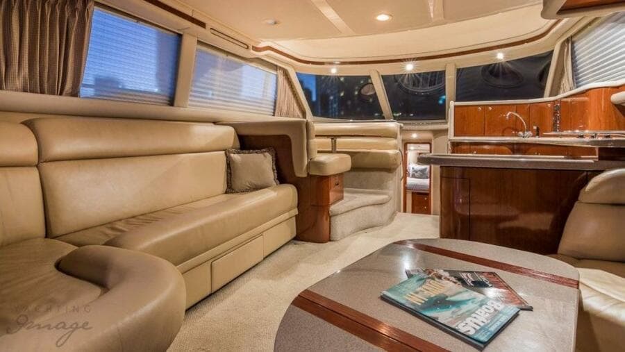 Luxurious interior of a 1998 Sea Ray 480 Sedan Bridge yacht with leather seating and modern kitchen.