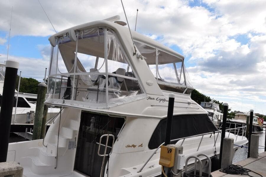 1998 Sea Ray 480 Sedan Bridge yacht docked at marina under cloudy sky.